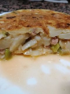 Una foto de Tortilla de patata con ajetes y jamón