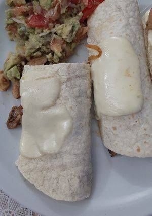 Una foto de Tacos de pollo cubiertos con queso mantecoso y Guacamole