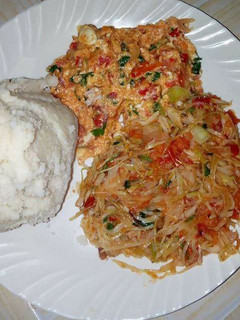 A picture of Fried Eggs, stewed Cabbages and Ugali.