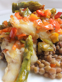Una foto de Corvina al horno con lentejas y verduras