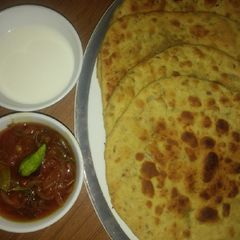 A picture of Besni masala prahta with tomato souce.