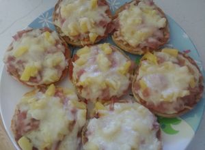 Una foto de Mini pizzas de piña, jamón y queso