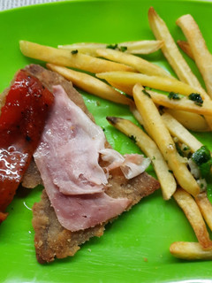 Una foto de Milanesa al horno con panceta, morrón asado, papas fritas
