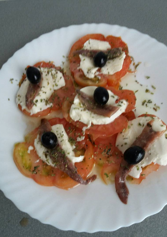 Una foto de Ensalada de tomate con mozzarella y anchoas