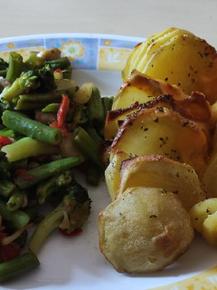 Una foto de Patatas Hasselback con cheddar y verduras salteadas