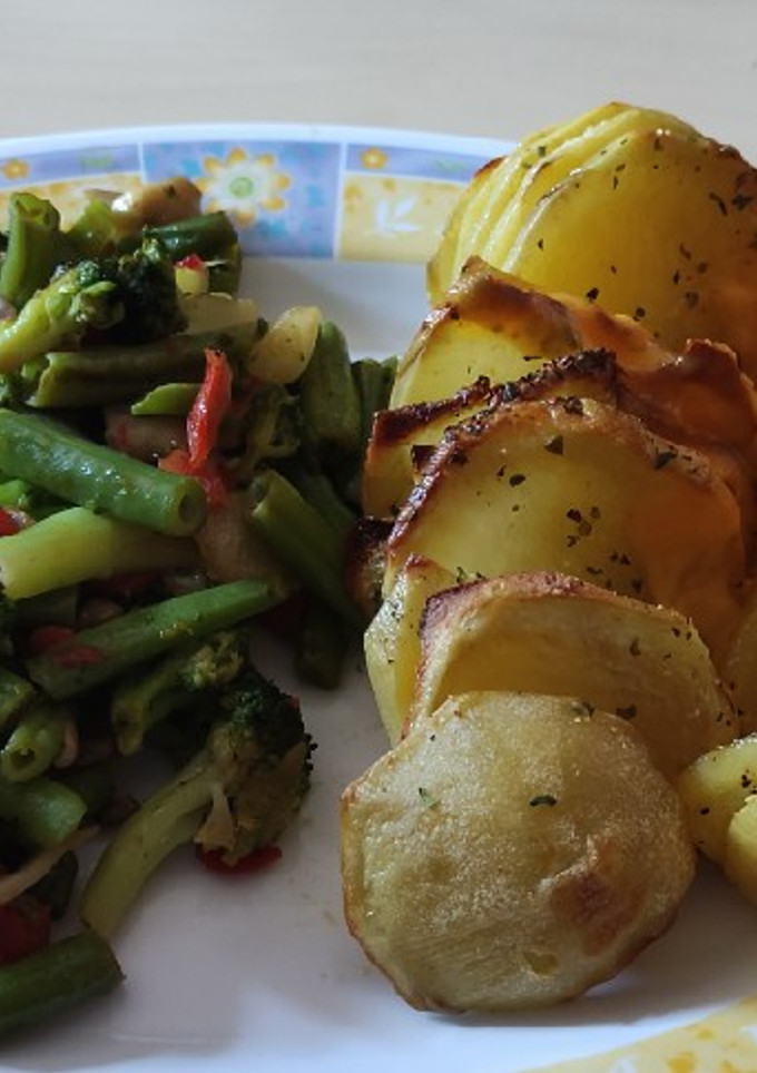 Una foto de Patatas Hasselback con cheddar y verduras salteadas