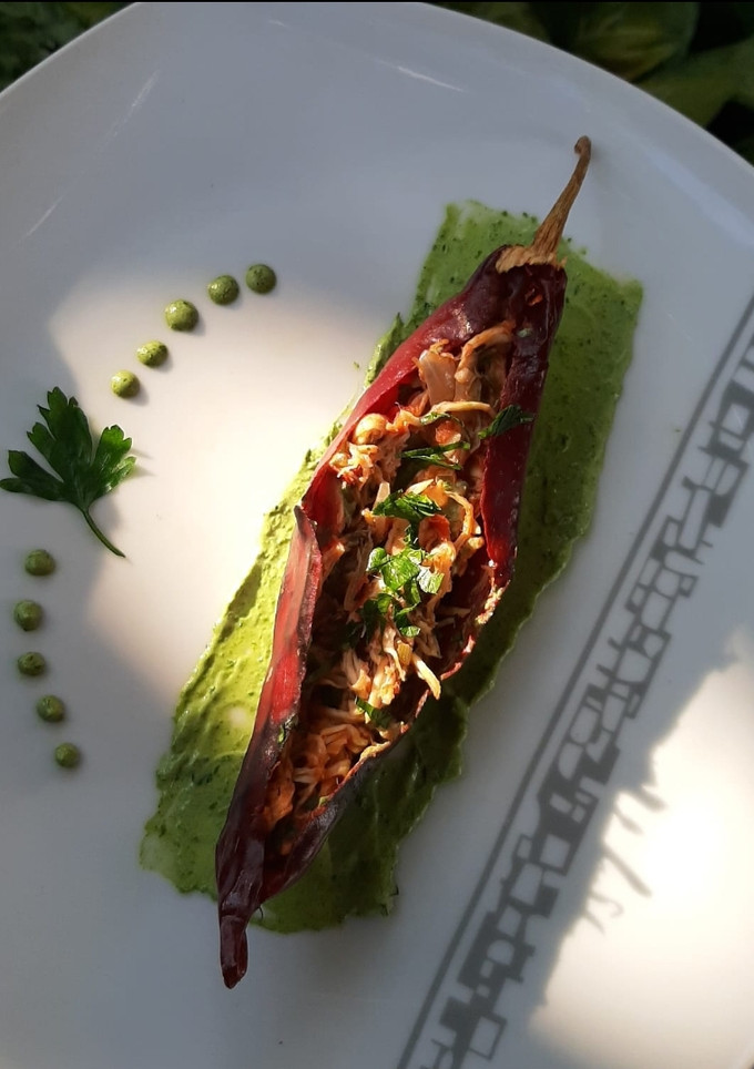 Una foto de Chile guajillo relleno, con crema de pereil