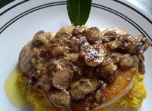 Una foto de Pechuga en salsa de champiñones en una cama de puré de plátano