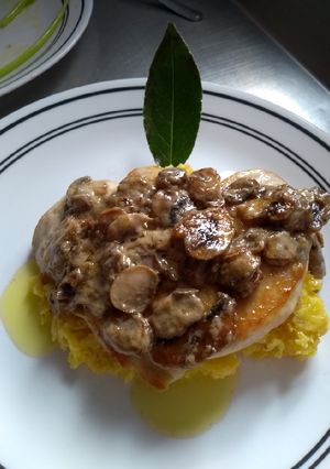 Una foto de Pechuga en salsa de champiñones en una cama de puré de plátano
