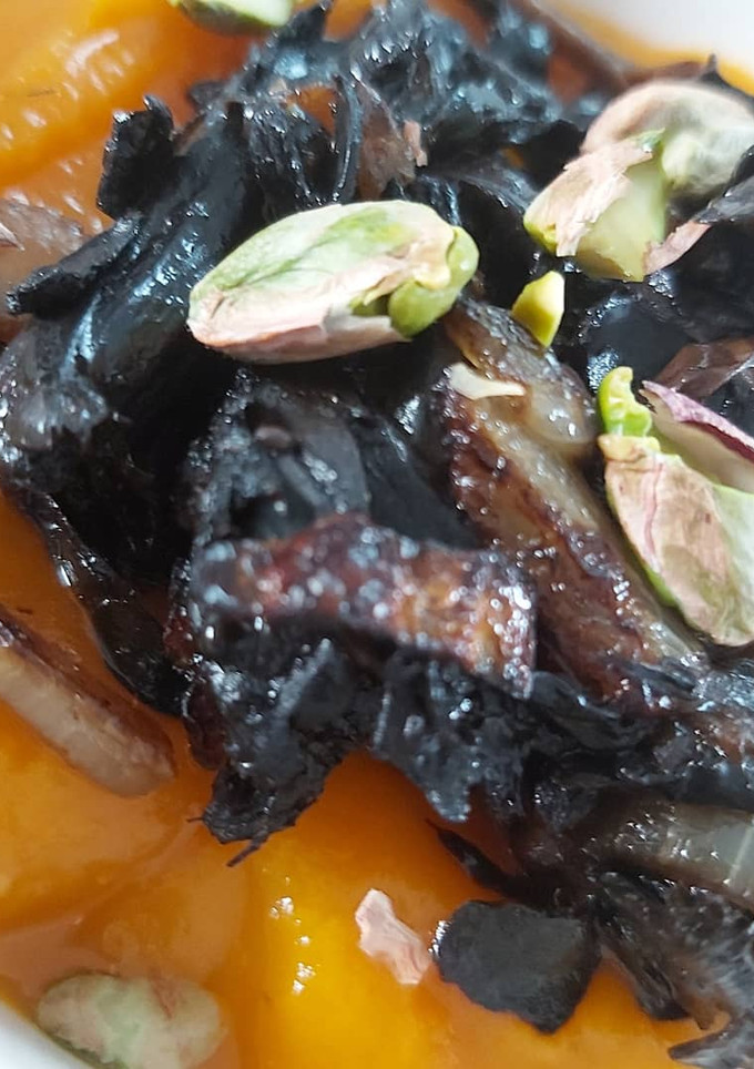 Una foto de Crema de calabaza con setas y pistachos