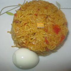 A picture of Jollof noodles with boiled egg.