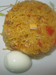A picture of Jollof noodles with boiled egg.