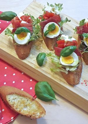 O poză a rețetei Bruschetti cu mozzarella, roșii cherry și busuioc.