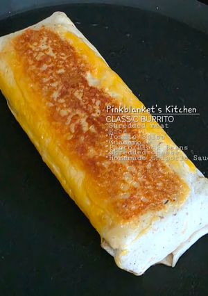 A picture of Classic Cheesy Shredded Meat Burrito with Homemade Creamy Chipotle Sauce.