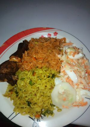 A picture of Fried and jollof rice combo garnished with coleslaw.
