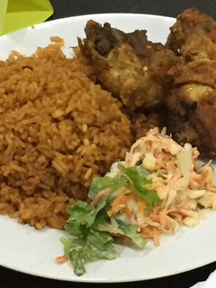 A picture of Jollof rice,fried chicken and coleslaw.