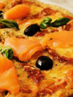 Una foto de Pizza de Salmón, Gambas, tomate seco y aceitunas negras