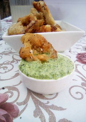 Una foto de Aros de cebolla y salsa de cilantro