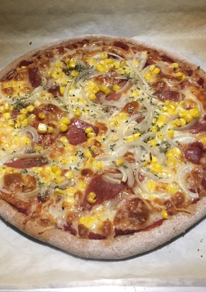 Una foto de Pizza casera de jamón serrano, maíz y cebolla de masa de espelta
