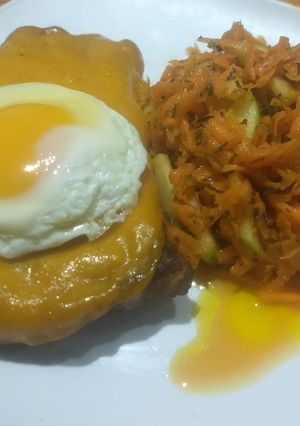 Una foto de Lomo en cheddar a caballo ensalada de zanahoria y manzana verde