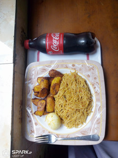 A picture of Jollof pasta and fried plantain with boiled egg.