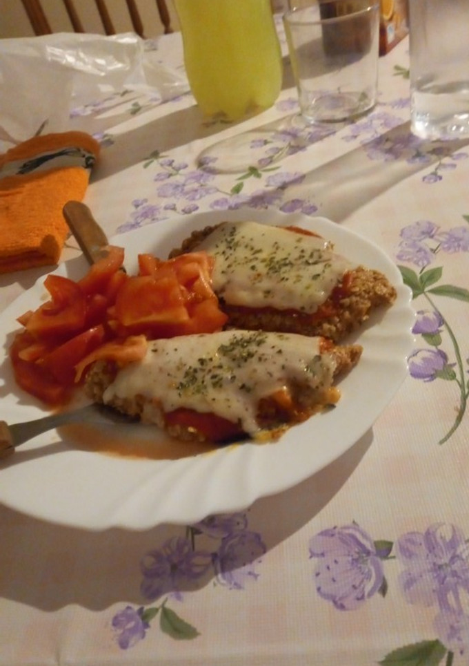 Una foto de Milanesa napolitana de pollo con tomate