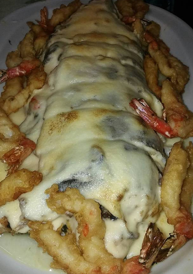 Una foto de Merluza rellena de espinacas, gambas y piñones