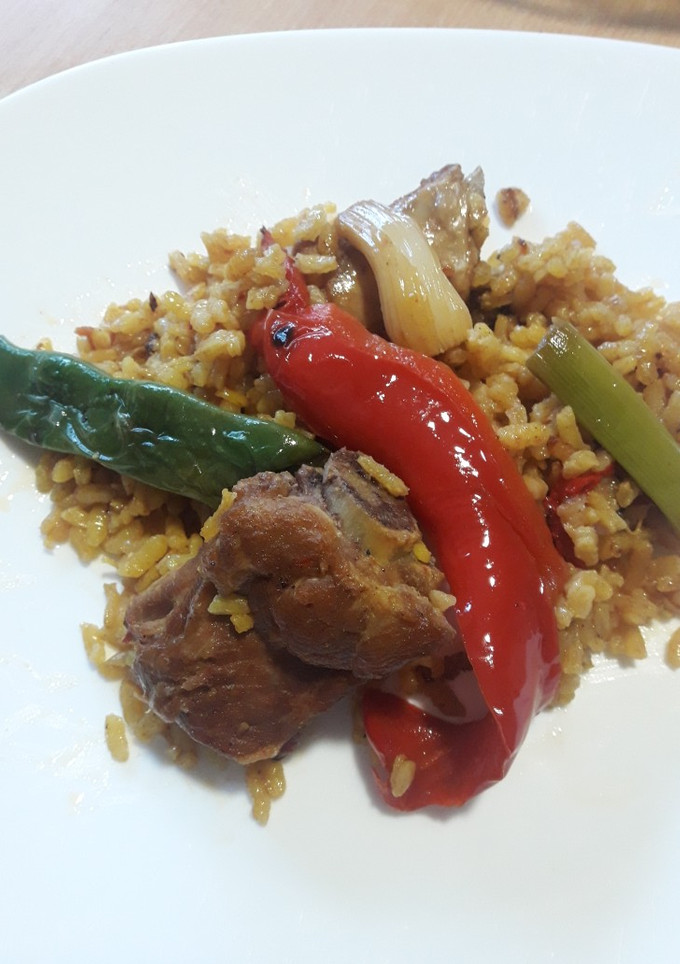 Una foto de Arroz al horno con costillas, garbanzos, pimientos y ajos tierno