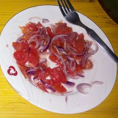 A picture of Onions and tomato salad.
