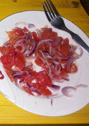 A picture of Onions and tomato salad.