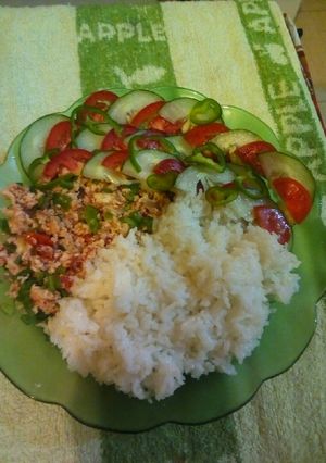 A picture of Steamed rice with scrambled eggs and cucumber salad.