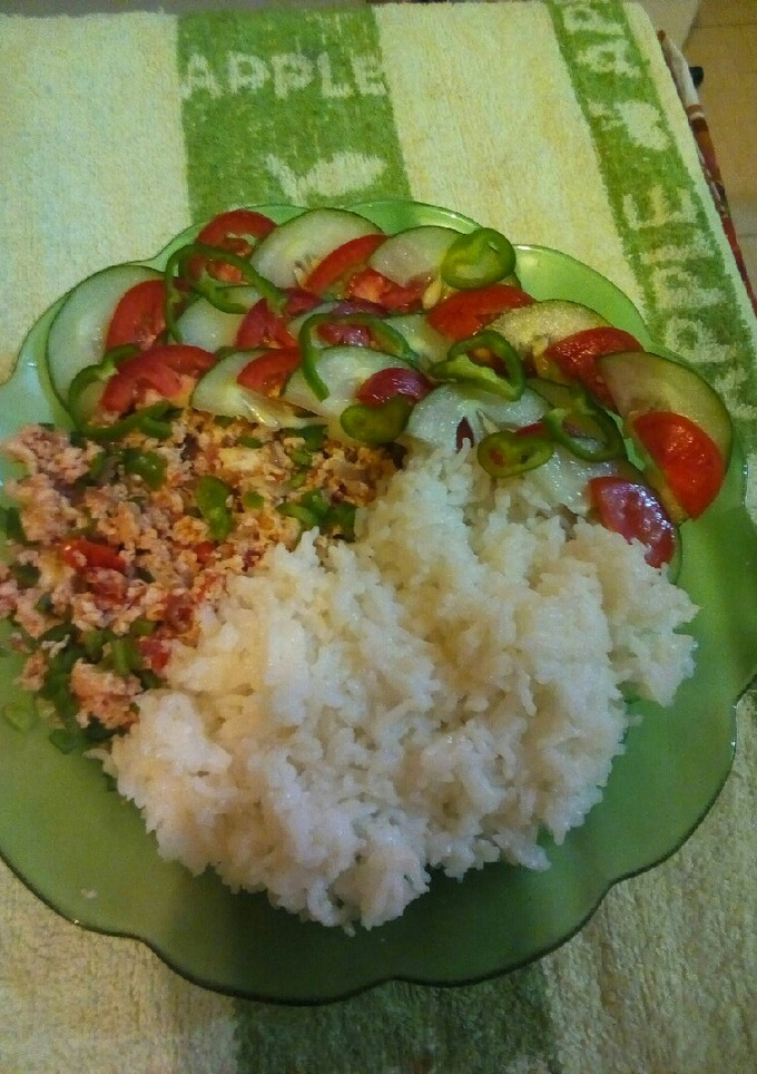 A picture of Steamed rice with scrambled eggs and cucumber salad.