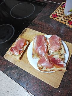 Una foto de Tostas de pan con tomate y jamón serrano