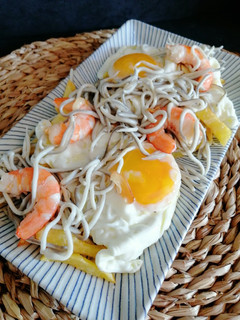 Una foto de Huevos rotos con gulas y langostinos