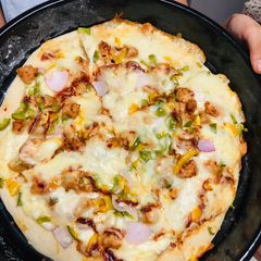 A picture of Giant chicken tikka pizza.