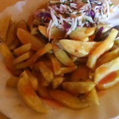 A picture of Chips served with chopped cabbage and chopped onions.