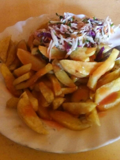 A picture of Chips served with chopped cabbage and chopped onions.