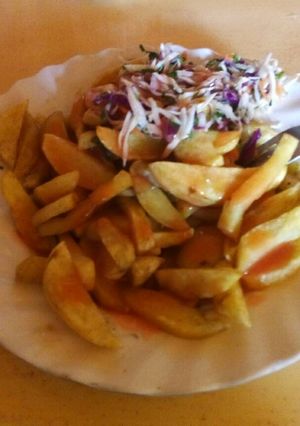 A picture of Chips served with chopped cabbage and chopped onions.