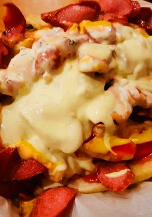 Una foto de Salchipapas con queso fundido