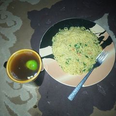 A picture of Spinach indomie noodles with lemon tea.