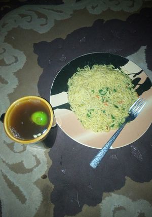 A picture of Spinach indomie noodles with lemon tea.