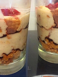 Una foto de Postre en vaso, copa o frasco con crema de banana, galletitas y nesquik