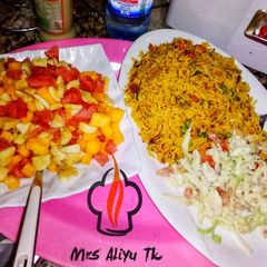 Jalof rice with coleslow and fruits salad A picture of Jalof rice with coleslow and fruits salad.