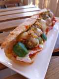 Bocata de albóndigas gratinadas en salsa de tomate con camembert y pesto