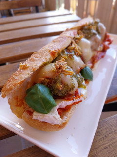 Una foto de Bocata de albóndigas gratinadas en salsa de tomate con camembert y pesto