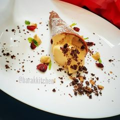 A picture of Cappuccino Mousse served with Chocolate cone and cookie crumbs.