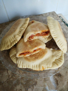 Una foto de Empanada de atún con tomate frito en el sartén