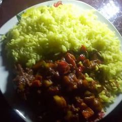 A picture of Chicken Afritada On Turmeric Rice.