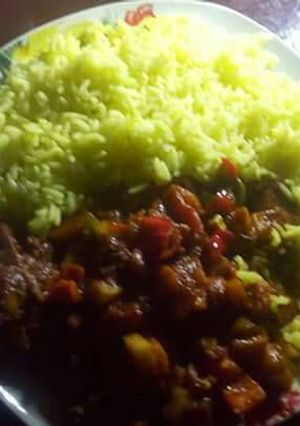 A picture of Chicken Afritada On Turmeric Rice.