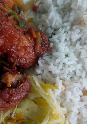 A picture of Stewed chicken with rice and veggies.